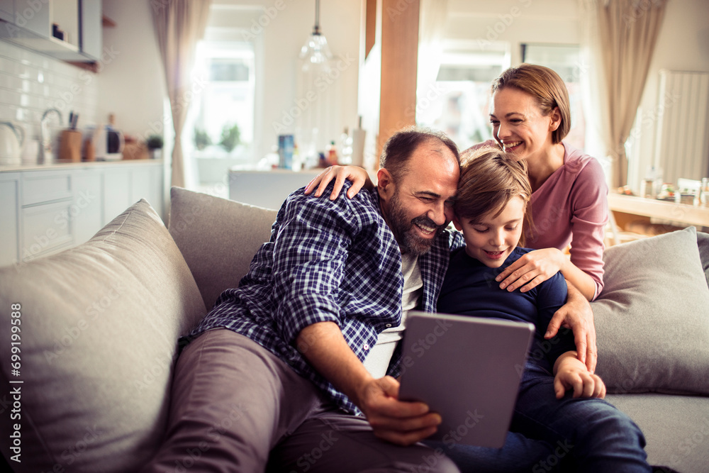 Happy family using tablet on the couch at home Happy family using tablet on the couch at home