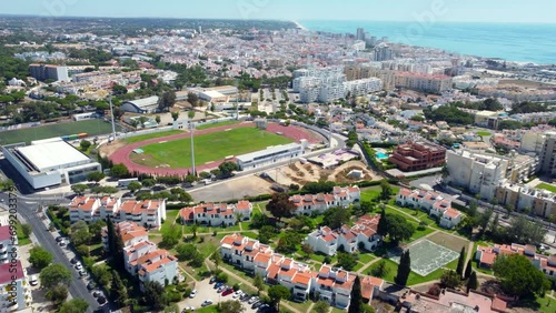 Aerial view of Quarteira city. View of Quarteira Municipal Stadium. Drone going forward above city center, close to Marina of Vilamoura. Panoramic view of all region. Algarve, Faro Province photo