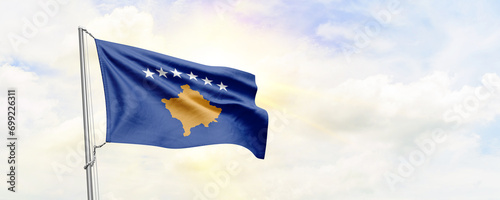 Kosovo flag waving on sky background. 3D Rendering