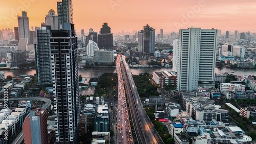 Cityscape of office building and car traffic illuminated crossing bridge on Chao Phraya river at Bangkok, Thailand photo