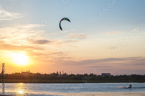 Sportsman kitesurfing during sunset