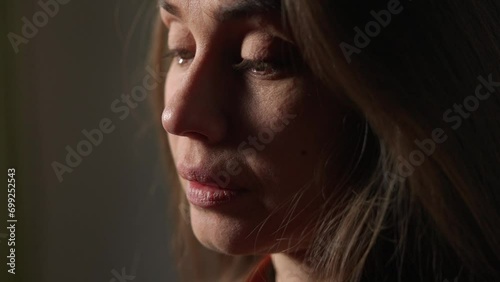 Portrait of attractive female model in negative mood. Close up shot brunette woman face in depressed mood, tears flowing down the face.