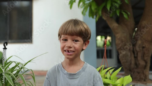 Happy preschooler smiles at camera and puts on sunglasses. Toothless smile .Summer holidays.