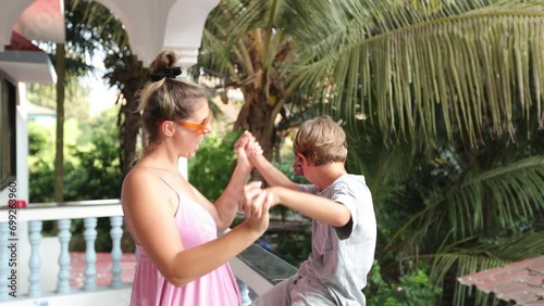 Happy, cheerful family. Mom, son on balcony at hotel having fun, playing, giving each other love. 