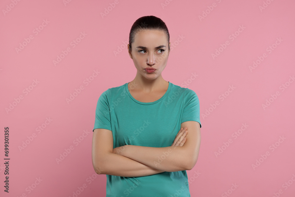 Portrait of resentful woman with crossed arms on pink background Portrait of resentful woman with crossed arms on pink background