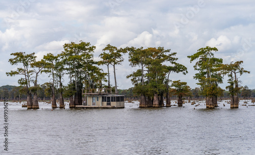 House boat with balcony moored in calm waters of the bayou of Atchafalaya Basin near Baton Rouge Louisiana