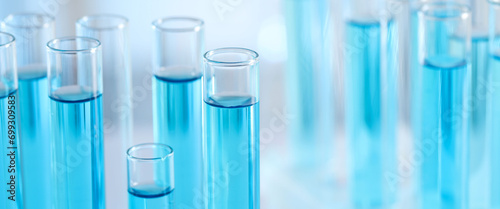 Laboratory analysis. Test tubes with liquid samples against blurred background, closeup. Banner design with space for text