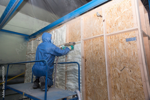 Insulation of walls with foam, energy and heat saving of walls, worker treats walls with foam © Anton