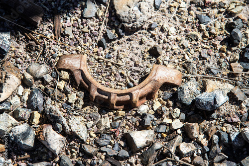 Old broken rusty piece of machinery on the ground among rocks