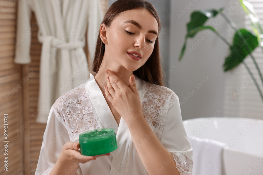 Young woman applying aloe gel onto her neck in bathroom Young woman applying aloe gel onto her neck in bathroom