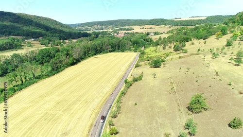 Car Overtaking Cyclists on Road Between Dry Fields - Haute Marne, France 4K Drone Footage
