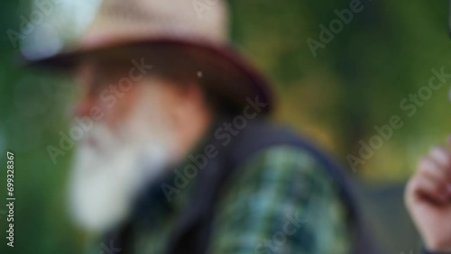 Concept of family vacation. Lunch together tradition. Grey bearded grandfather sitting in chair and telling life stories to his little grandson. Fishing with grandchild. Eating sandwiches in forest photo