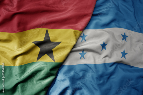 big waving national colorful flag of honduras and national flag of ghana .