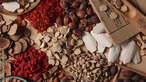 Ancient Chinese medicine and different herbal ingredients on table.