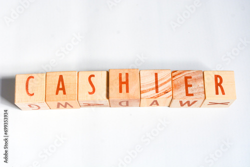 Wooden blocks make up the word "CASHIER" in English. Wooden block object