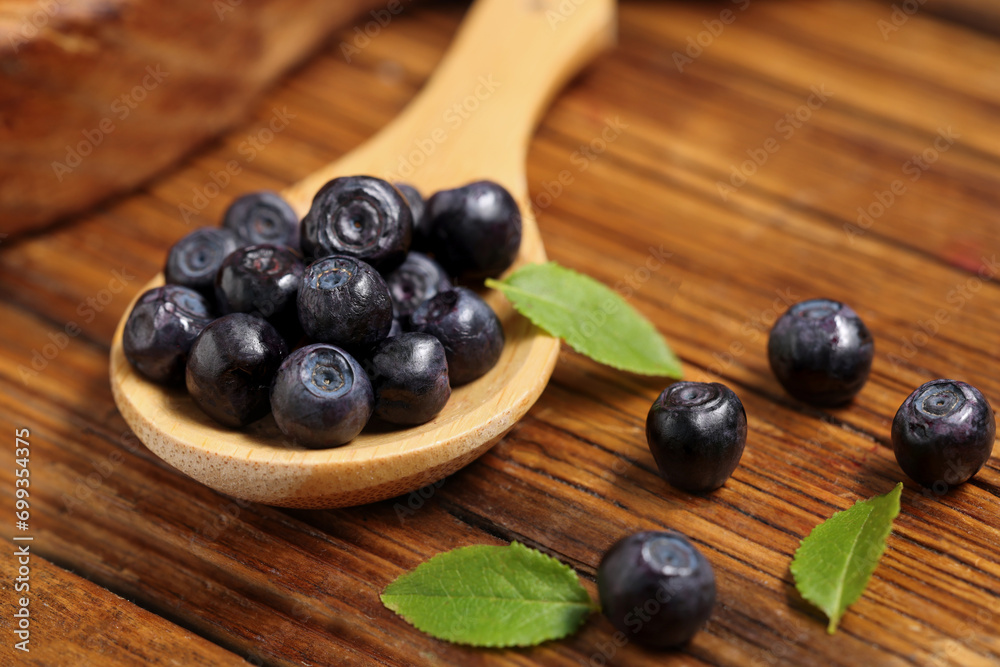 Ripe bilberries and leaves on wooden table, closeup Ripe bilberries and leaves on wooden table, closeup