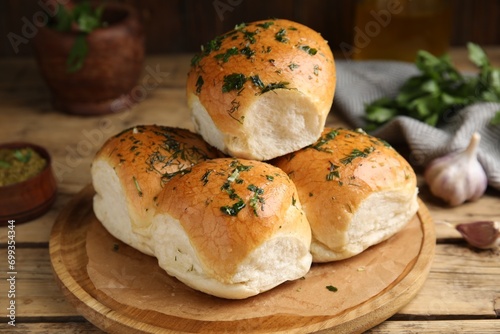 Traditional pampushka buns with garlic and herbs on wooden table photo