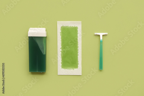 Safety razor with liposoluble wax cartridge and strip on green background photo