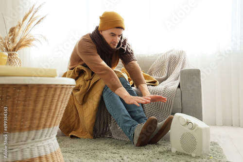 Young man warming hands nea...