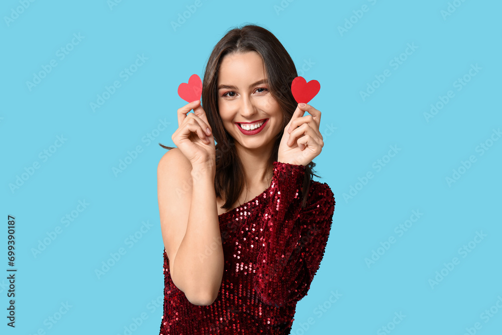 Beautiful young woman with red paper hearts on blue background. Valentine's Day celebration Beautiful young woman with red paper hearts on blue background. Valentine's Day celebration