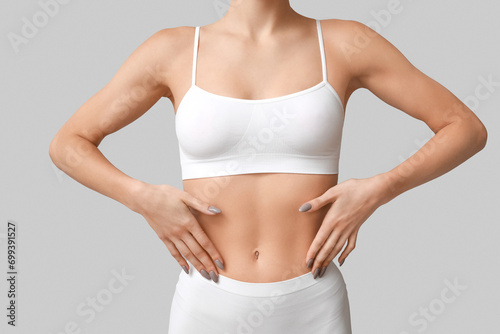 Young woman in underwear on light background, closeup. Plastic surgery concept