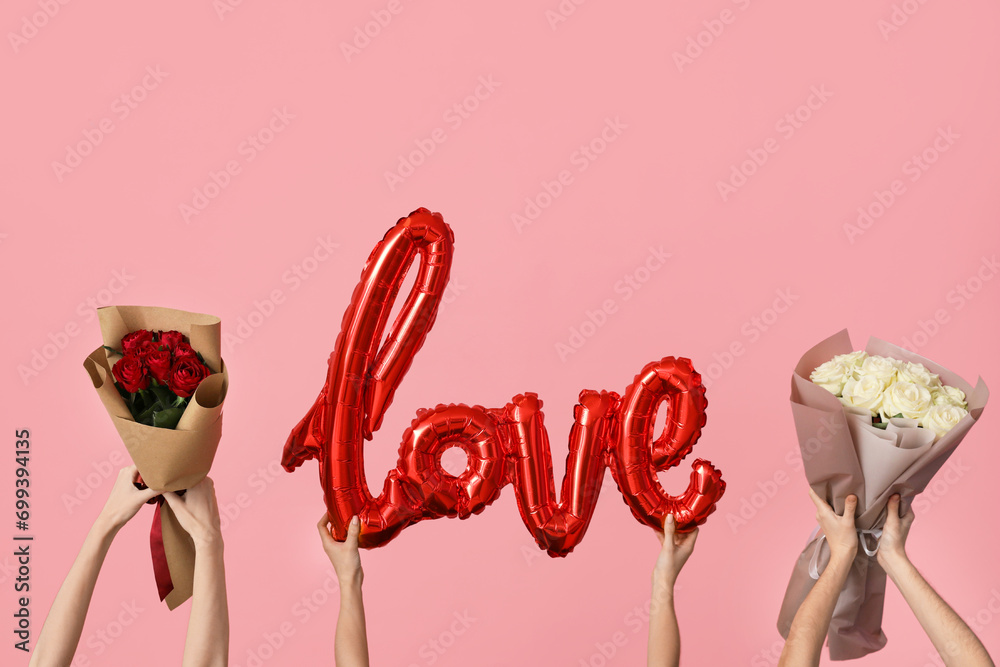 Women with word LOVE made of balloons and roses on pink background. Valentine's Day celebration