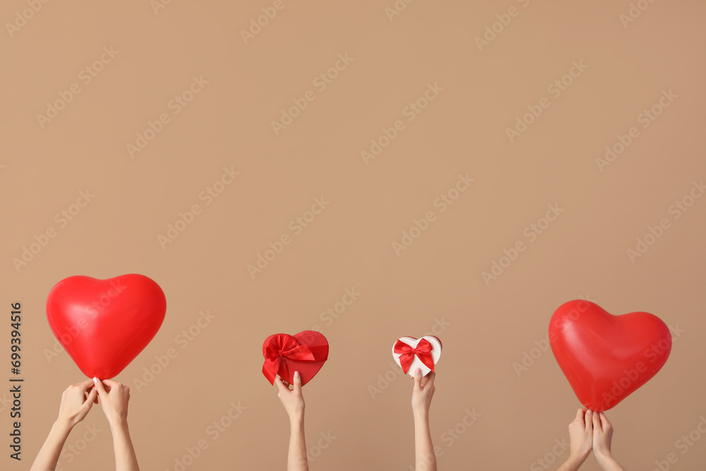 Women with heart-shaped balloons and gifts on brown background. Valentine's Day celebration