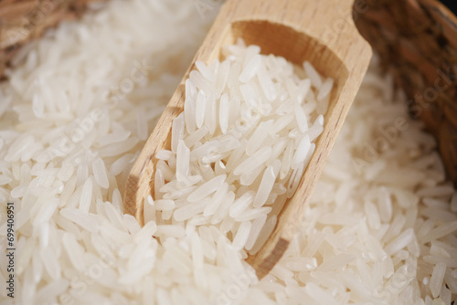 Raw white rice on a wooden spoon