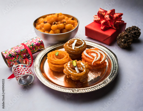 indian sweet jalebi imarti laddu and gujiya served together over white background photo