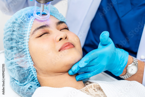 Asian Doctor doing laser on the woman face at beauty clinic. Beautiful woman having facial skin care treatment at beauty clinic, Facial skin care, anti-aging facial rejuvenation.