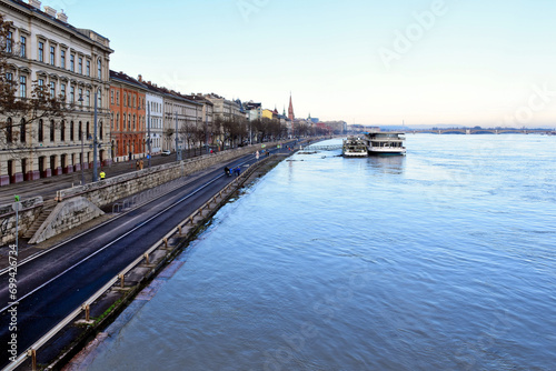 Budapest, Hungary - 12. 26. 2023. Aerial view of the flooding Danube river from the Chain bridge. high water level reaching the quay and asphalt low road closed to car traffic. pedestrians strolling © Istvan