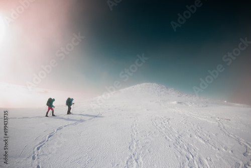 climbers climb the mountain. Winter mountaineering. two girls in snowshoes walk through the snow. photo