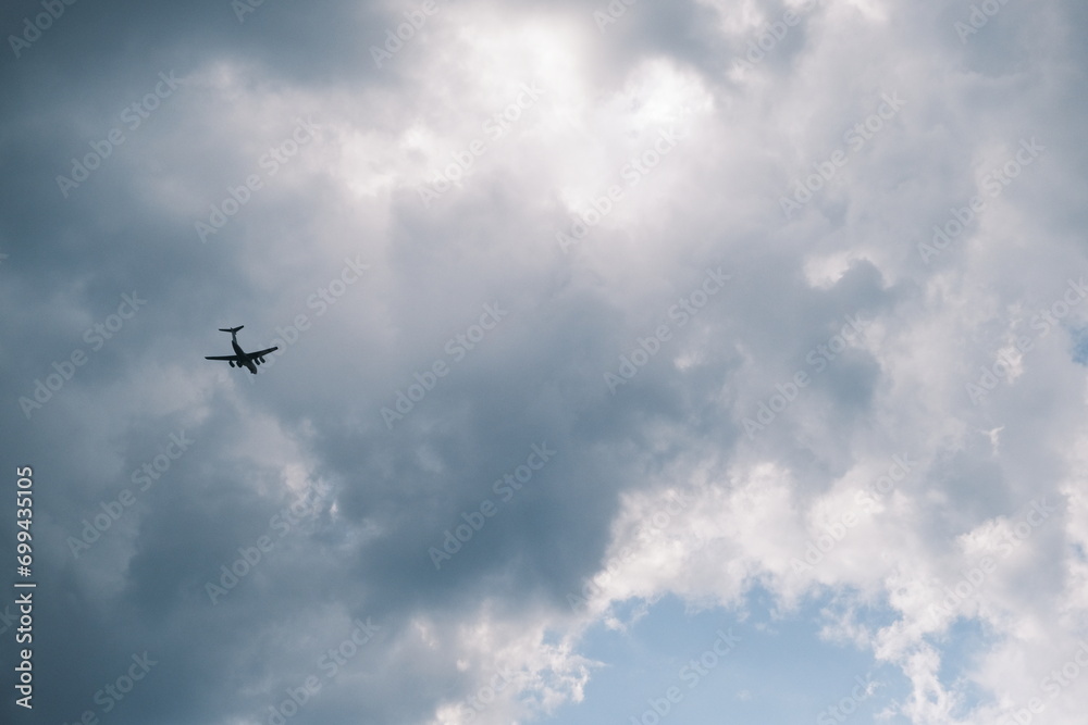 White passenger airplane flying in the sky clouds in the background White passenger airplane flying in the sky clouds in the background