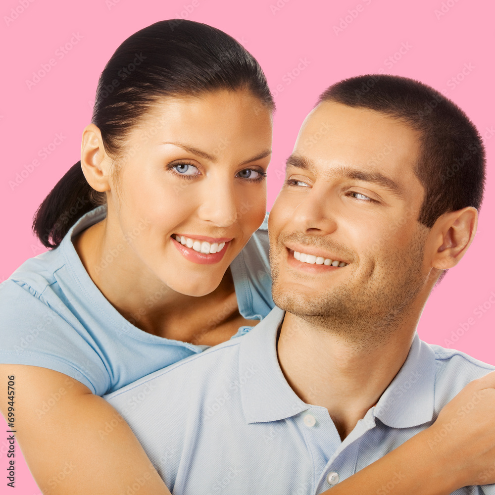Happy amazed smiling couple. Portrait of standing close embracing pair in love studio concept, isolated rose pink background. Young man and woman posing together. Square composition photo Happy amazed smiling couple. Portrait of standing close embracing pair in love studio concept, isolated rose pink background. Young man and woman posing together. Square composition photo