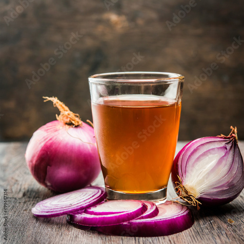 medicinal onion juice/syrup in a glass with raw onions. selective focus photo