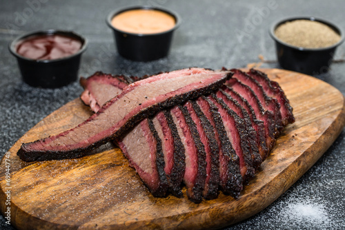 Foto Beef Brisket platter steak meat sliced isolated on wooden board with dip sauce t