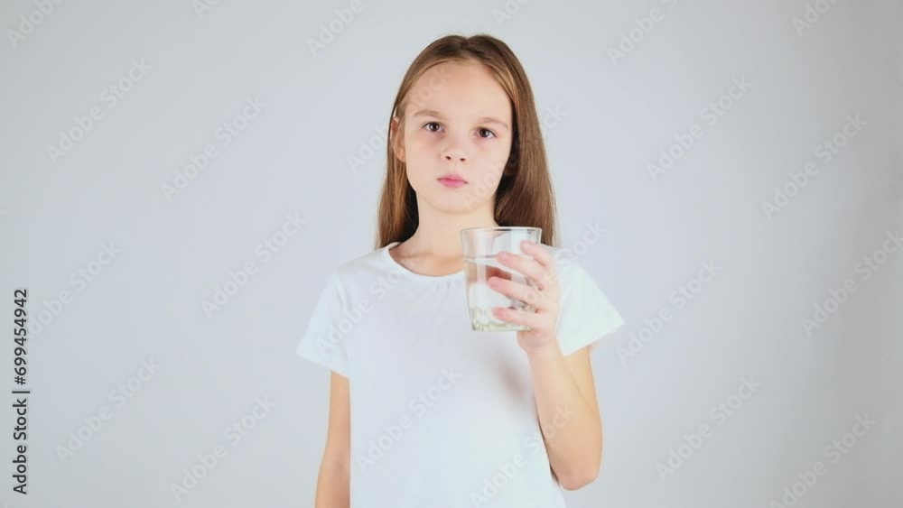 Pretty preteen girl, child with a fresh glass of water, isolated on studio white background, healthy lifestyle concept. Stock ビデオ | Adobe Stock