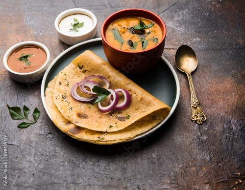 onion rava masala dosa is a south indian instant breakfast served with chutney and sambar over moody background