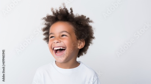 A professional portrait studio photo of a cute mixed race boy child model with perfect clean teeth laughing and smiling. isolated on white background