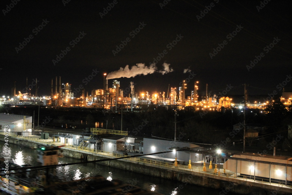 night view of a petroleum refining plant and a canal