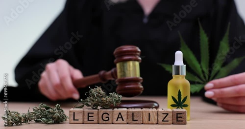 Word legalization on wooden cubes on background of marijuana and judge with gavel 4k movie slow motion. photo