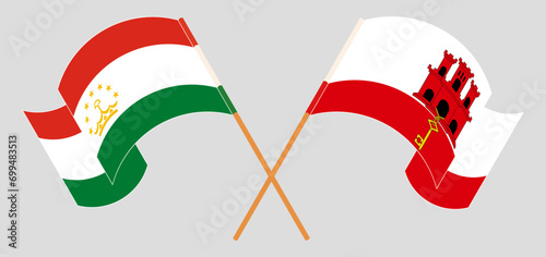 Crossed and waving flags of Tajikistan and Gibraltar photo