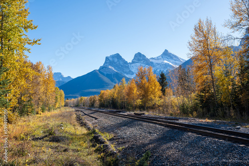 Railway scenery in fall season. The Three Sisters trio of peaks over the blue sky. Canmore, Alberta, Canada.