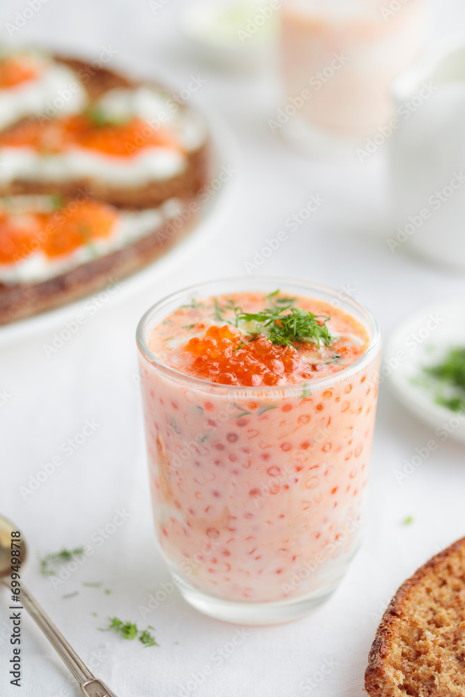 Appetizer with red caviar, sour cream, dill, onion and rye bread on the white table - the finnish recipe for a holiday food, close up in minimalistic style Appetizer with red caviar, sour cream, dill, onion and rye bread on the white table - the finnish recipe for a holiday food, close up in minimalistic style