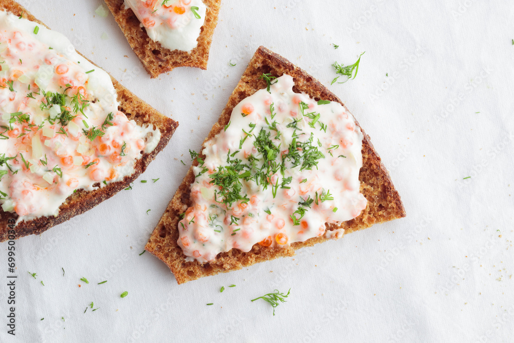 Appetizer with red caviar, sour cream, dill, onion and rye bread on the white table - the finnish recipe for a holiday food, flat lay in minimalistic style Appetizer with red caviar, sour cream, dill, onion and rye bread on the white table - the finnish recipe for a holiday food, flat lay in minimalistic style