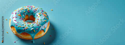 Unhealthy junk food. Delicious donut on a pastel blue color background with colorful decorations. Banner with copy space photo