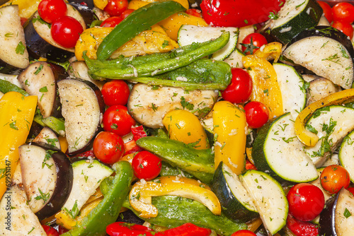 Salad of fresh vegetables, cherry tomatoes, zucchini, eggplant, lettuce and herbs.