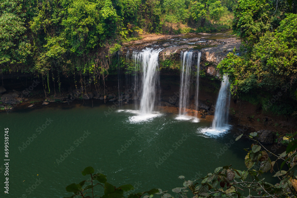 Three waterfalls flowing from the rocks among the trees in the forest. Bolaven Plateau, Laos Three waterfalls flowing from the rocks among the trees in the forest. Bolaven Plateau, Laos