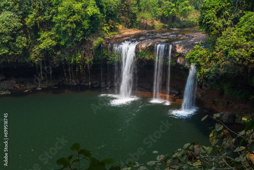 Three waterfalls flowing from the rocks among the trees in the forest. Bolaven Plateau  Laos