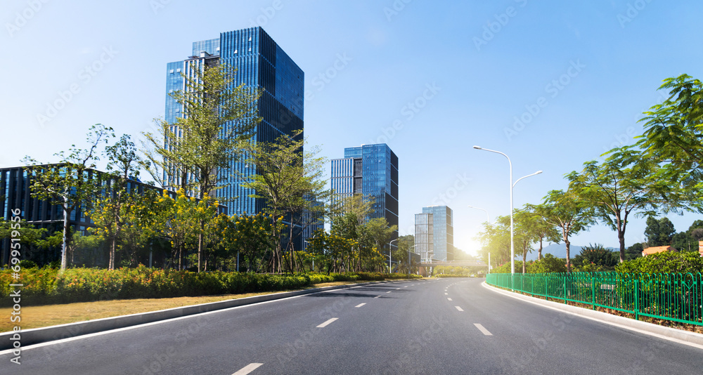 Empty asphalt road near office buildings